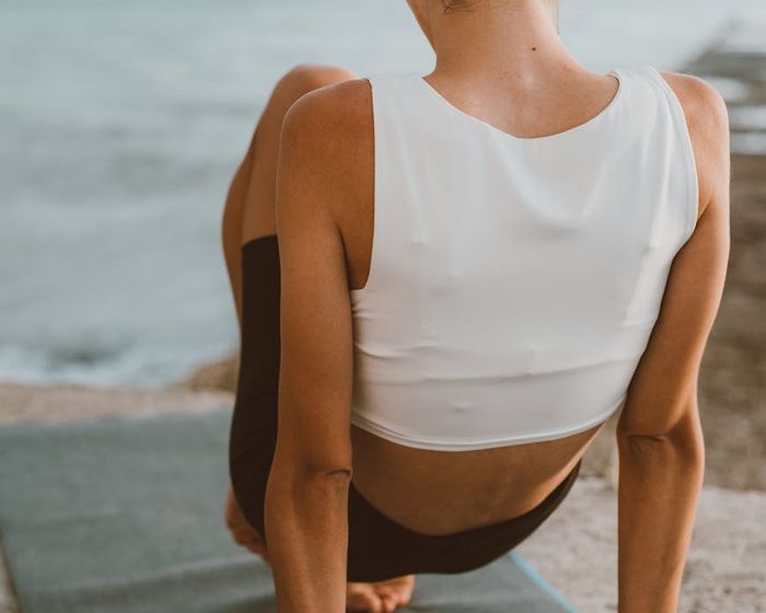 A serene landscape with a person practicing yoga at sunrise.